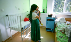 Une jeune mère ne souhaitant pas être identifiée avec son bébé de dix mois ayant peut-être contracté la rougeole, à l'hôpital  de Piatra Neamt, en Roumanie, le 23 juin 2025. ( AFP / Daniel MIHAILESCU )