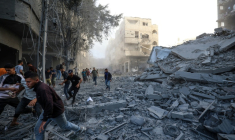 Des personnes courent se mettre à l'abri après une frappe israélienne qui a visé un bâtiment dans le camp de réfugiés palestiniens de Bureij, dans le centre de la bande de Gaza, le 19 octobre 2025 ( AFP / Eyad BABA )