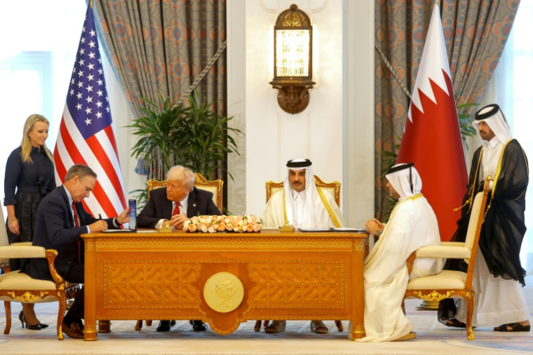 L'émir du Qatar Tamim ben Hamad Al Thani et le président américain Donald Trump, tous deux au centre de la photo, avec les PDG de Boeing Kelly Ortberg (G) et de Qatar Airways Badr Mohammed al-Meer (D) signant des documents au Royal Palace de Doha le 14 mai 2025. ( AFP / Karim JAAFAR )