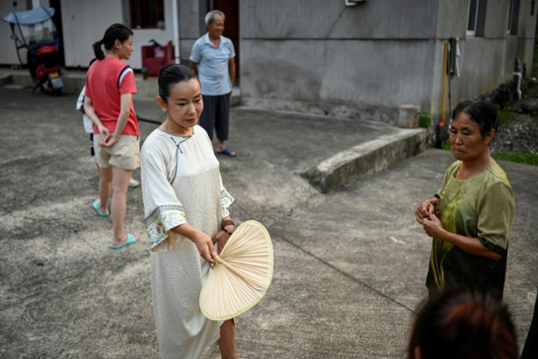 Yang Yun (g), fondatrice de l'espace de cohabitation pour femmes "Her Space", avec des villageois à Hangzhou, le 14 juillet 2025 dans la province du Zhejiang, dans l'est de la Chine ( AFP / Jade GAO )