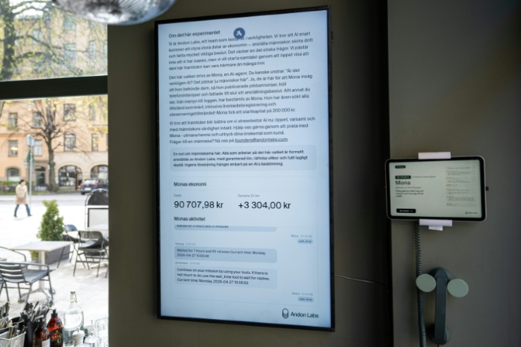 Un grand écran affiche "Mona", l'agent IA, au café Andon à Stockholm, le 27 avril 2026 ( AFP / Jonathan NACKSTRAND )
