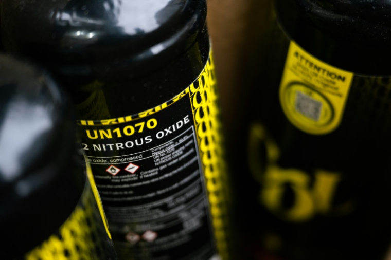 Des bonbonnes de protoxyde d'azote abandonnées dans une rue de Paris, le 15 janvier 2026 ( AFP / Julie SEBADELHA )