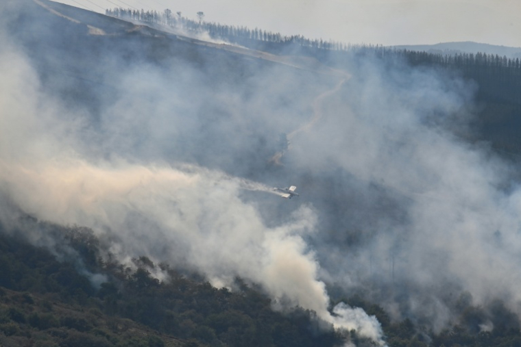 Un avion largue de l'eau sur un incendie à Maceda, au nord-ouest de l'Espagne, le 13 août 2025 ( AFP / MIGUEL RIOPA )