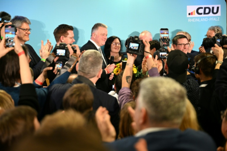Gordon Schneider (c), candidat tête de liste du parti conservateur CDU aux élections régionales de Rhénanie-Palatinat, arrive au parlement régional de Mayence pour s'adresser à ses partisans, pendant la publication des premiers sondages de sortie des urnes, le 22 mars 2026 en Allemagne ( AFP / DANIEL PETER )