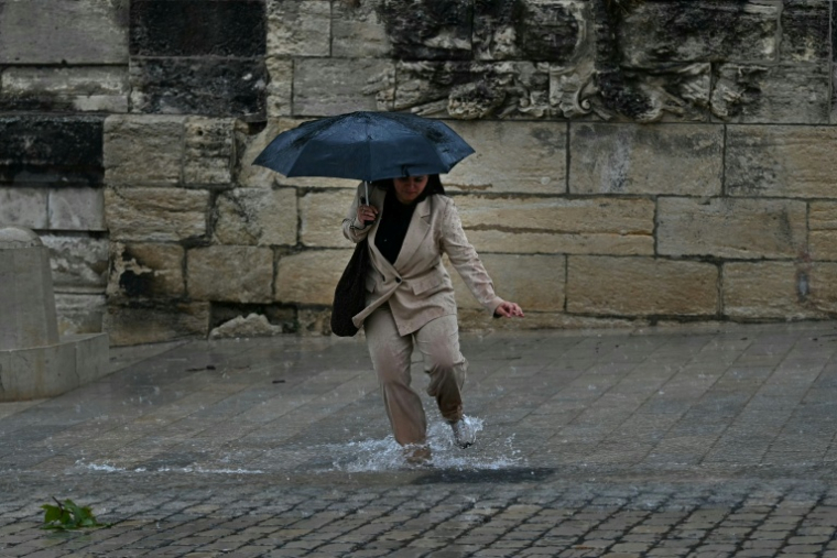 Une femme marche sous la pluie à Montpellier dans le sud de la France le 30 septembre 2026 ( AFP / Gabriel BOUYS )