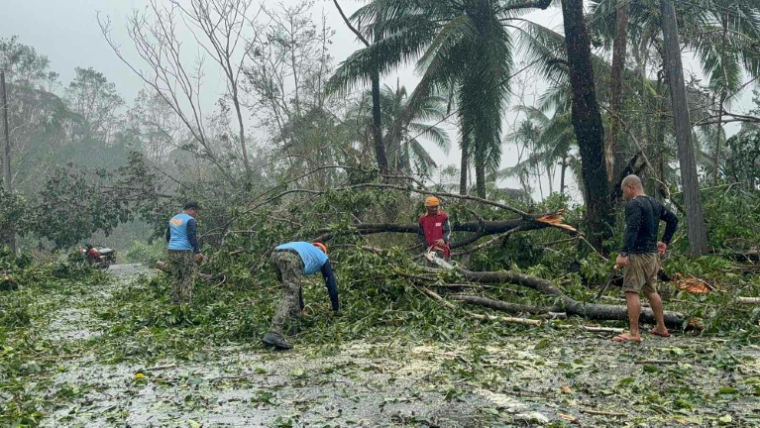 Des policiers et des habitants déblayent une route encombrée d'arbres déracinés par le typhon Kalmaegi à Silago, dans la province de Leyte, aux Philippines, le 4 novembre 2025 ( AFP / - )