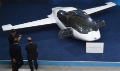 Des visiteurs regardent un prototype du premier taxi volant, l'eVTOL - jet électrique à décollage et atterrissage vertical - de la société Lilium. Salon Digital Summit (Digital Gipfel) à Nuremberg (sud de l'Allemagne), le 4 décembre 2018. ( AFP / CHRISTOF STACHE )