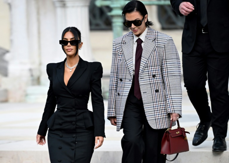 L'influenceuse américaine Kim Kardashian (c), accompagnée de sa mère Kris Jenner (d), quitte la cour d'assises de Paris, le 13 mai 2025, après avoir témoigné dans le procès du braquage dont elle a été victime en 2016 ( AFP / LEO VIGNAL )