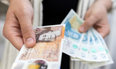 Photo d'illustration d'une femme tenant des billets de banque en livres sterling