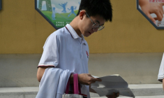 Un lycéen consulte un manuel avant d'affronter l'examen national d'entrée à l'université, connu sous le nom de "Gaokao", à l'extérieur d'un lycée de Pékin, le 7 juin 2025 ( AFP / Adek BERRY )