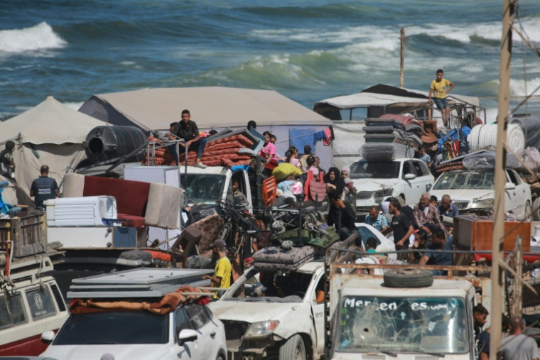 Des Palestiniens transportant leurs effets personnels traversent une route côtière au nord-ouest de Nousseirat (centre) après leur fuite de Gaza-ville, le 1er octobre 2025 ( AFP / Bashar TALEB )