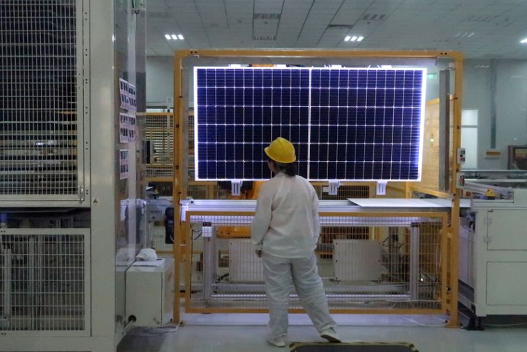 Une ouvrière effectue un contrôle qualité d'un module solaire dans une usine du fabricant d'équipements solaires en silicium monocristallin