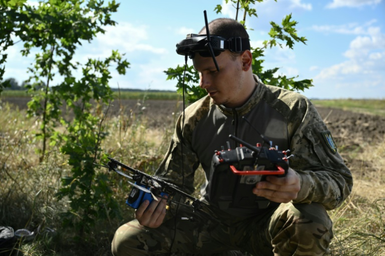 Le pilote de drone ukrainien Lafayette vérifie un drone avant un vol d'entraînement dans l'est de l'Ukraine, le 16 août 2025 ( AFP / Genya SAVILOV )