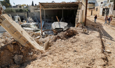 Des enfants palestiniens marchent près d'une route endommagée dans le camp de Jénine, en Cisjordanie occupée