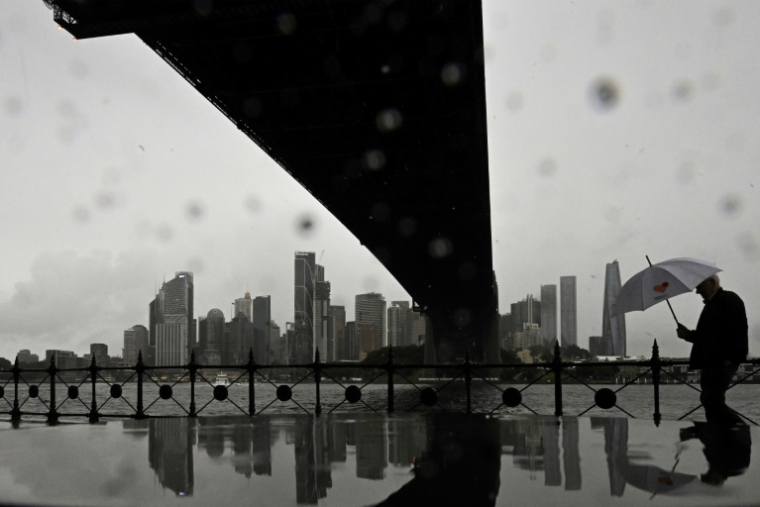 La ville de Sydney, en Australie, dans la brume, visible à travers les trombes d'eau le 22 mai 2025 ( AFP / Saeed KHAN )