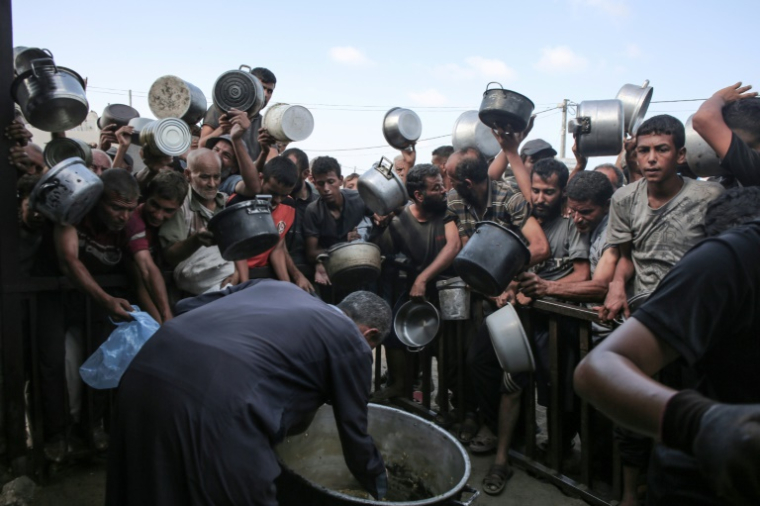 Des Palestiniens déplacés se bousculent pour recevoir un repas à Khan Younès, dans le sud de la bande de Gaza, le 19 septembre 2025 ( AFP / - )