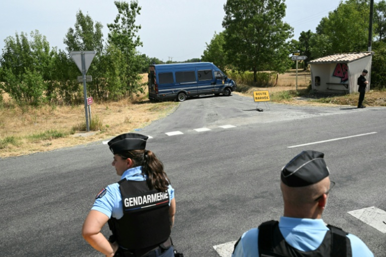 Des gendarmes devant une route bloquée près du site où sont menées des recherches pour retrouver le corps de Delphine Aussaguel, le 16 juillet 2026 à Villenue-sur-Vère, dans le Tarn ( AFP / Lionel BONAVENTURE )