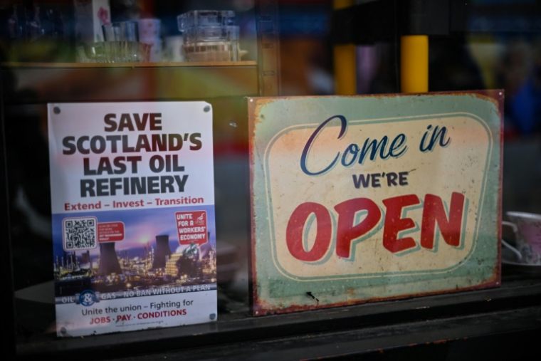 Une affiche sur la vitrine d'une boutique du quartier commerçant de Charlotte Dundas Court, près de la raffinerie de Grangemouth dans le sud de l'Écosse, le 7 mai 2025 ( AFP / Andy Buchanan )