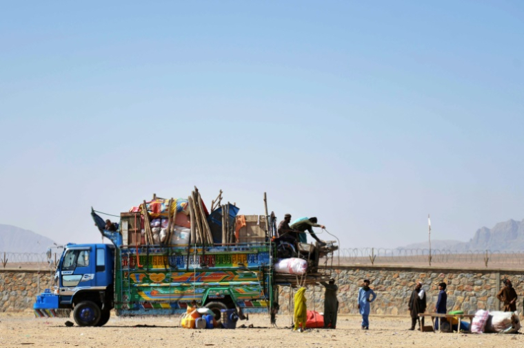 Le 7 mai 2025, des réfugiés afghans arrivent du Pakistan et déchargent leurs affaires dans le district de Takhta Pul, province de Kandahar ( AFP / Sanaullah SEIAM )