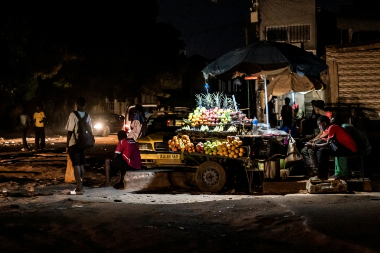 Un vendeur de fruits attend des clients à son étal lors d'une coupure d'électricité à Westfield, en Gambie, le 12 septembre 2026, alors que des coupures prolongées perturbent les activités commerciales et la vie quotidienne dans tout le pays ( AFP / MUHAMADOU BITTAYE )