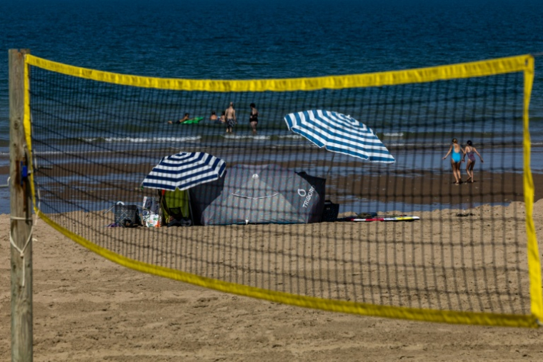 Des touristes sur la plage à Villers-sur-Mer, dans le Calvados, le 26 août 2026 ( AFP / JOEL SAGET )