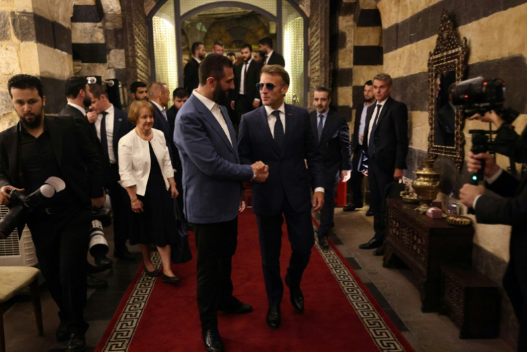 Le président français Emmanuel Macron (à droite) et le président syrien Ahmad al-Chareh arrivent pour un dîner dans un restaurant de la vieille ville de Damas, le 6 juillet 2026. ( AFP / Ludovic MARIN )