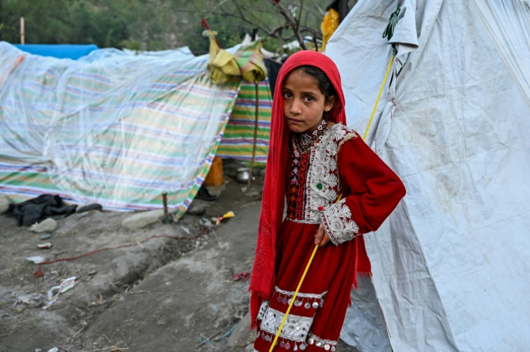 Une petite fille afghane devant une tente, dans la région de Kunar, en Afghanistan, le 12 avril 2026 ( AFP / Wakil KOHSAR )