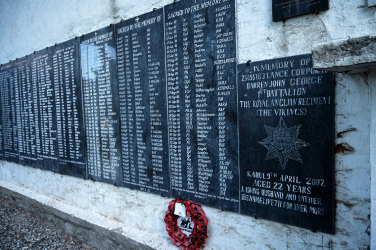 Des plaques portant les noms de soldats étrangers morts pendant la guerre en Afghanistan sur un mur  du cimetière britannique à Kaboul, le 22 mai 2025 ( AFP / Wakil KOHSAR )