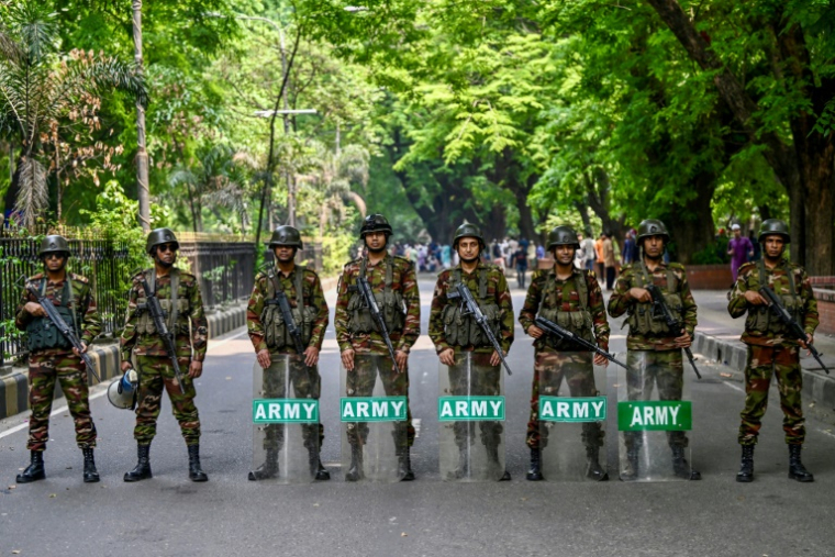 Des soldats devant la résidence officielle du chef du gouvernement intérimaire du Bangladesh, Muhammad Yunus, lors d'une manifestation pour demander l'interdiction du parti de Sheikh Hasina, la Ligue Awami, à Dacca, le 9 mai 2025 ( AFP / Munir UZ ZAMAN )