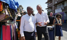 Édouard Philippe (c), fondateur et président du parti Horizons, maire du Havre et candidat à l'élection présidentielle, et Ambdilwahedou Soumaila (g), maire de Mamoudzou visitent une rue commerçante de Mamoudzou, le 21 août 2026 sur l'île de Mayottte ( AFP / Marine Gachet )
