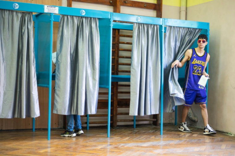Un électeur vote au second tour de la présidentielle roumaine, le 18 mai 2025 à Bucarest ( AFP / Mihai Barbu )