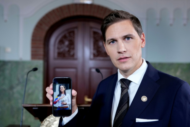 Le président du comité Nobel norvégien, Jorgen Watne Frydnes, montre sur son smartphone une photo de la dirigeante de l'opposition vénézuélienne María Corina Machado, lauréate du prix Nobel de la paix 2025, à l'Institut Nobel norvégien à Oslo, le 10 octobre 2025 ( NTB / Rodrigo Freitas )
