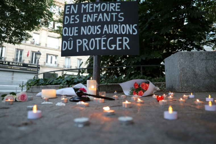 Une pancarte "À la mémoire des enfants que nous aurions dû protéger" lors d'une veillée aux chandelles en hommage à la collégienne Lyhanna, place des droits de l'enfant, le 12 juin 2026 à Paris ( AFP / Kenzo TRIBOUILLARD )