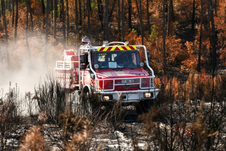 Un camion de pompiers au milieu d'une végétation en partie détruite par un incendie à Lège-Cap-Ferret, en Gironde, le 1er août 2026  ( AFP / ROMAIN PERROCHEAU )