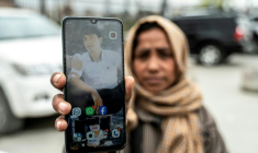 L'Afghane Samira Muhammadi montre une photo de son fils, tué lors d'une frappe aérienne pakistanaise sur un hôpital, alors qu'elle le recherche pendant la deuxième cérémonie funéraire collective devant la mosquée Eid Gah à Kaboul, le 26 mars 2026 en Afghanistan ( AFP / Wakil KOHSAR )