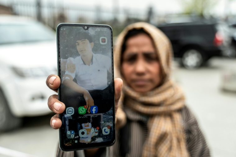 Samira Muhammadi montre une photographie de son fils, Aref Khan, devant la mosquée Eid Gah à Kaboul, le 26 mars 2026 ( AFP / Wakil KOHSAR )