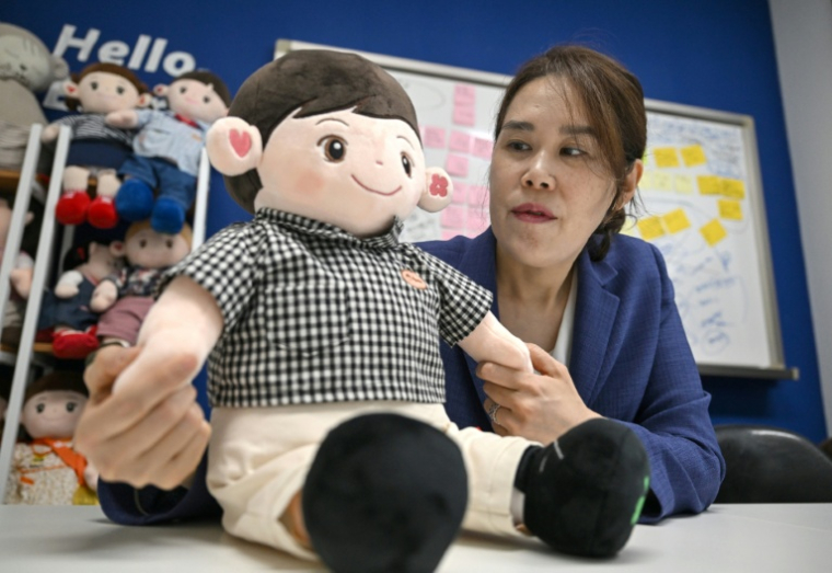 La directrice de la start-up Hyodol, Kim Ji-hee, montre l'une des poupées IA pour les  personnes âgées conçues et fabriquées par l'entreprise, le 6 mai 2026 à Anyang, en Corée du Sud ( AFP / Jung Yeon-je )
