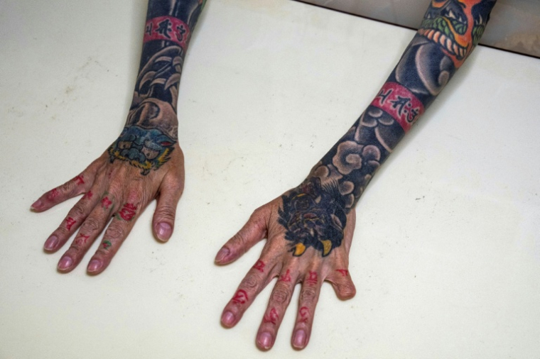 Une yazuka à la retraite, Mako Nishimura, montre ses tatouages et son petit doigt amputé. à Gifu (centre), le 28 septembre 2025 ( AFP / YUICHI YAMAZAKI )