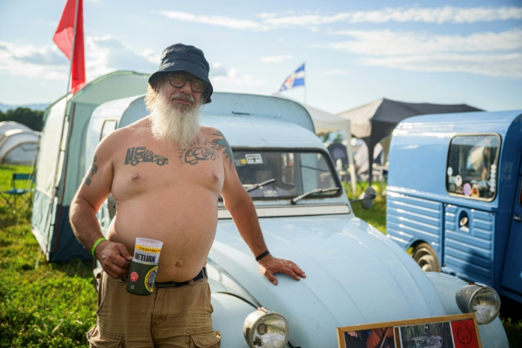 Gabriele Salvoni, un Italien de 55 ans, pose devant sa 2CV lors d'un rassemblement organisé à Postojna en Slovénie, le 30 juillet 2025 ( AFP / Jure Makovec )