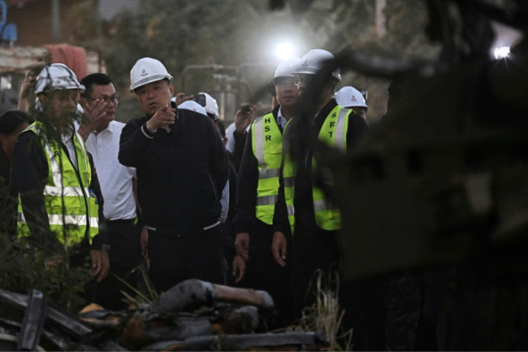 Le Premier ministre thaïlandais Anutin Charnvirakul inspecte l'épave d'un train qui a déraillé lorsqu'une grue de chantier s'est effondrée dans la province thaïlandaise de Nakhon Ratchasima, le 14 janvier 2026 ( AFP / Lillian SUWANRUMPHA )