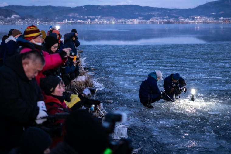 Des fidèles du culte shinto effectuent des relevés sur le lac Suwa, le 29 janvier 2026 à Nagano, dans le centre du Japon  ( AFP / Philip FONG )