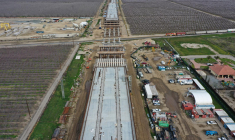 Cette image aérienne montre un train de marchandises passant sous le viaduc de Hanford en construction dans le cadre du projet de transport ferroviaire à grande vitesse de Californie (CAHSR) à Hanford, en Californie, le 12 février 2025.  ( AFP / PATRICK T. FALLON )