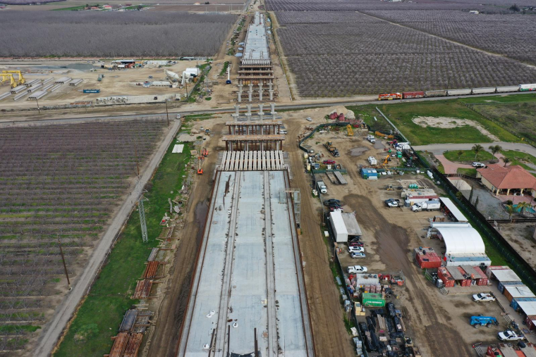 Cette image aérienne montre un train de marchandises passant sous le viaduc de Hanford en construction dans le cadre du projet de transport ferroviaire à grande vitesse de Californie (CAHSR) à Hanford, en Californie, le 12 février 2025.  ( AFP / PATRICK T. FALLON )