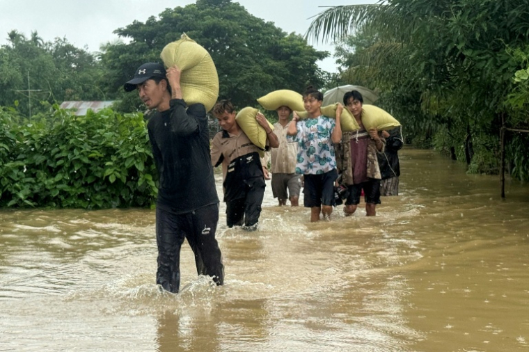 Des habitants sur une route inondée après des inondations causées par des pluies de mousson à Kyauktaw, dans l'ouest de la Birmanie, le 10 juillet 2026  ( AFP / STR )