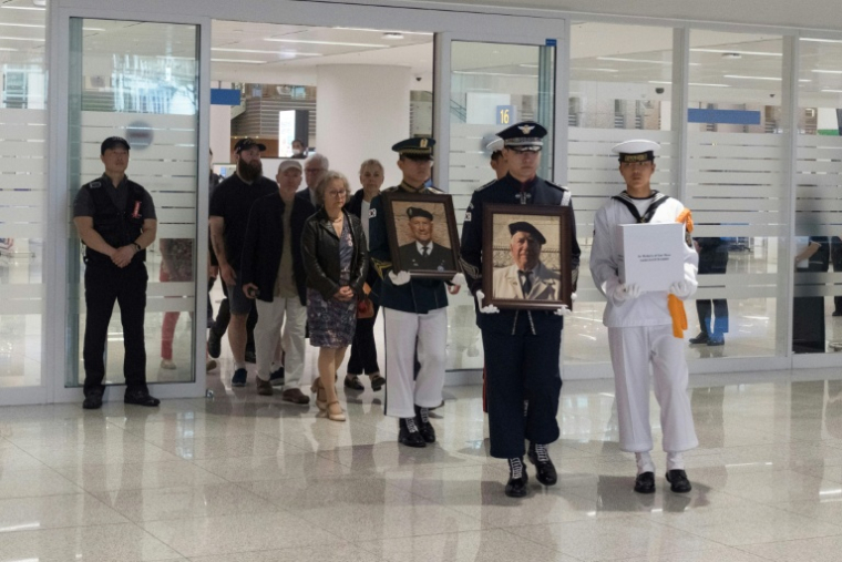 Des soldats transportent les cendres des vétérans français de la guerre de Corée, André Datcharry et Jacques Grisolet, à leur arrivée à l'aéroport international de Séoul, le 26 mai 2026 en Corée du Sud ( AFP / Roland DE COURSON )