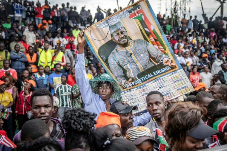 Un partisan de l'opposant kényan Raila Odinga brandit une pancarte alors que la foule investit le stade où sa dépouille doit être exposée, à Kisumu, dans l'ouest du Kenya, le 18 octobre 2025 ( AFP / Luis TATO )
