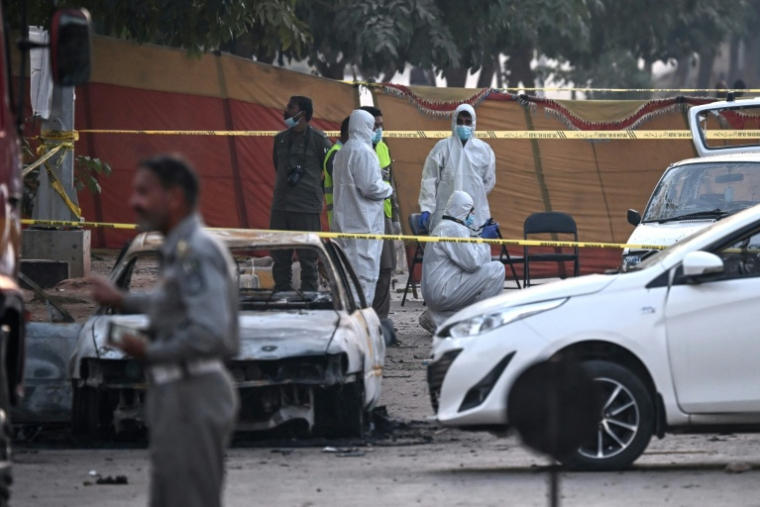 Des experts examinent une voiture après l'attentat-suicide, le 11 novembre 2025 à Islamabad ( AFP / Farooq NAEEM )