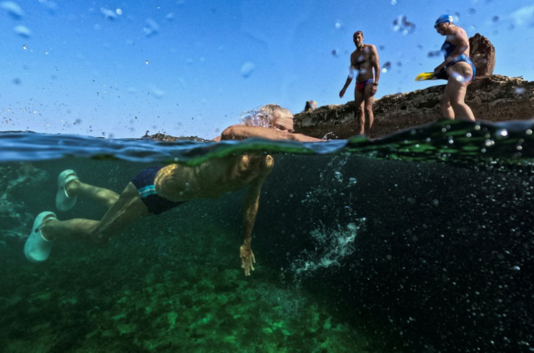 Un homme, membre du club "Jeunesse accumulée", nage dans une piscine d'eau de mer à La Havane, le 17 mai 2025 ( AFP / YAMIL LAGE )