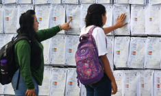 Deux femmes regardent le "mur de la victoire" à l'extérieur du centre logistique électoral, où a lieu le recomptage des voix de l'élection présidentielle du Honduras, à Tegucigalpa le 19 décembre 2025 ( AFP / Orlando SIERRA )
