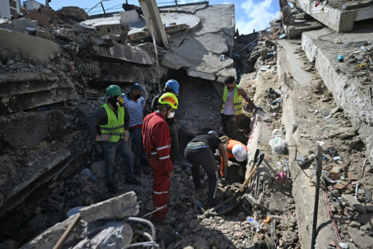 Des secouristes et bénévoles recherchent des survivants dans les déocombres de bâtiments effondrés à Caraballeda, dans l'Etat de La Guaira, le 1er juillet 2026 au Venezuela ( AFP / Juan BARRETO )